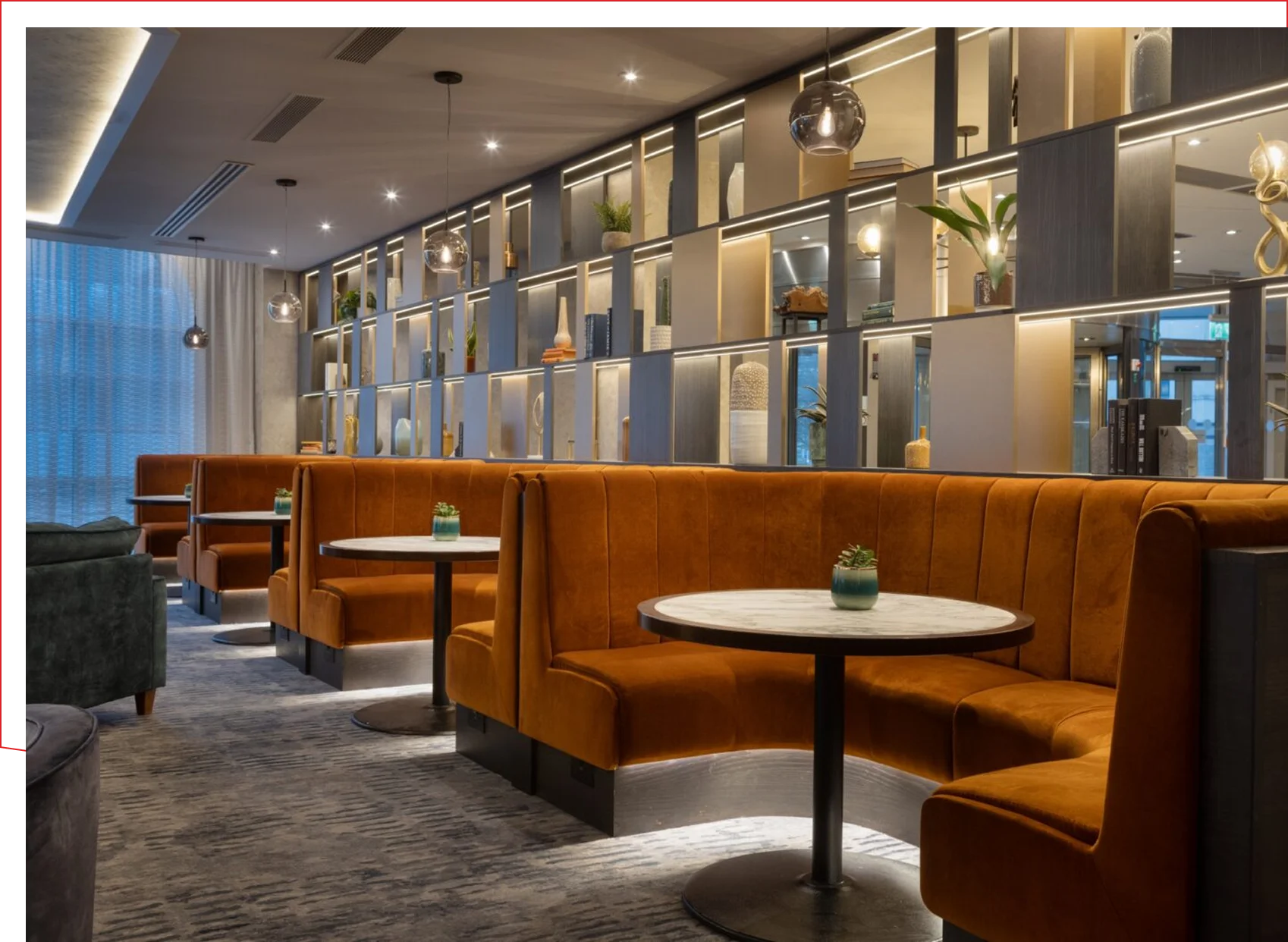Frame 1618873881 (3) Modern restaurant interior with orange booths.