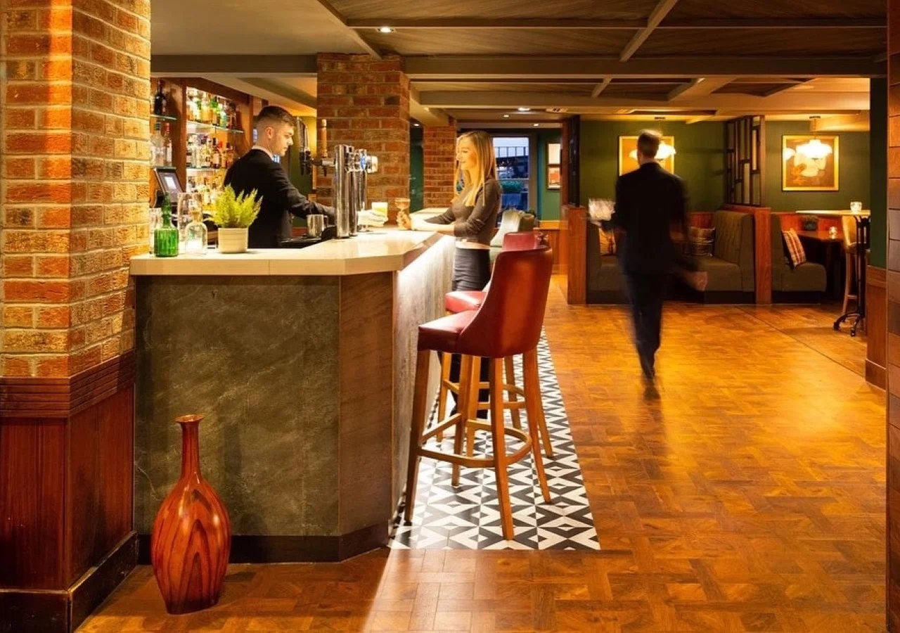 Bar interior with people and bartender.