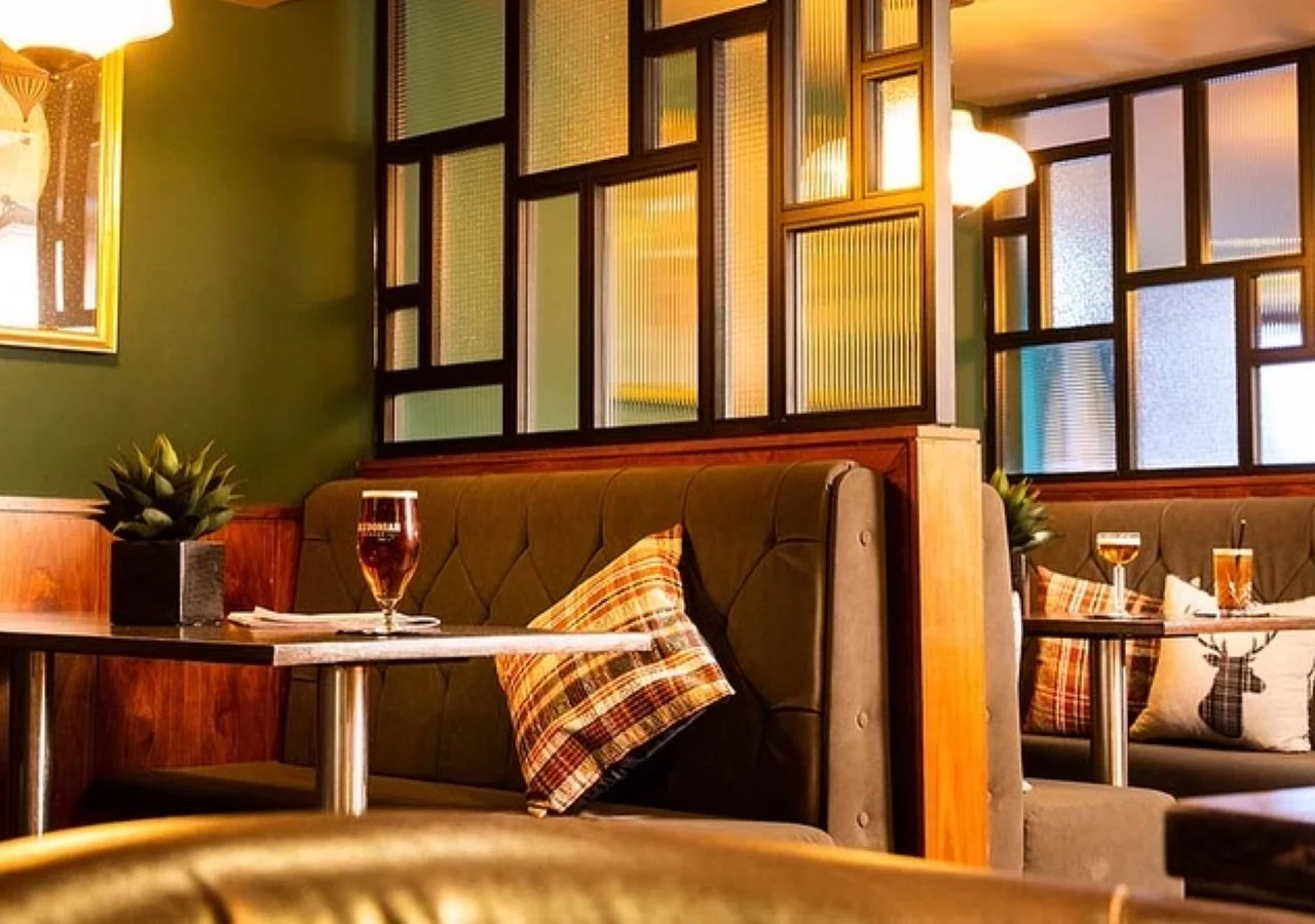 Cozy restaurant booth with drinks and pillows.